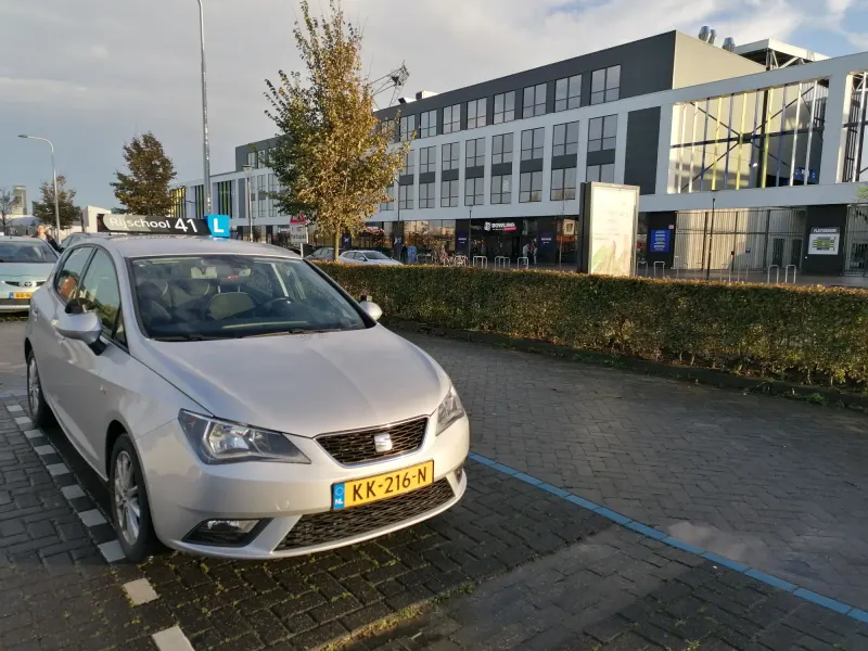 Rijschool 41 lesauto geparkeerd bij het station